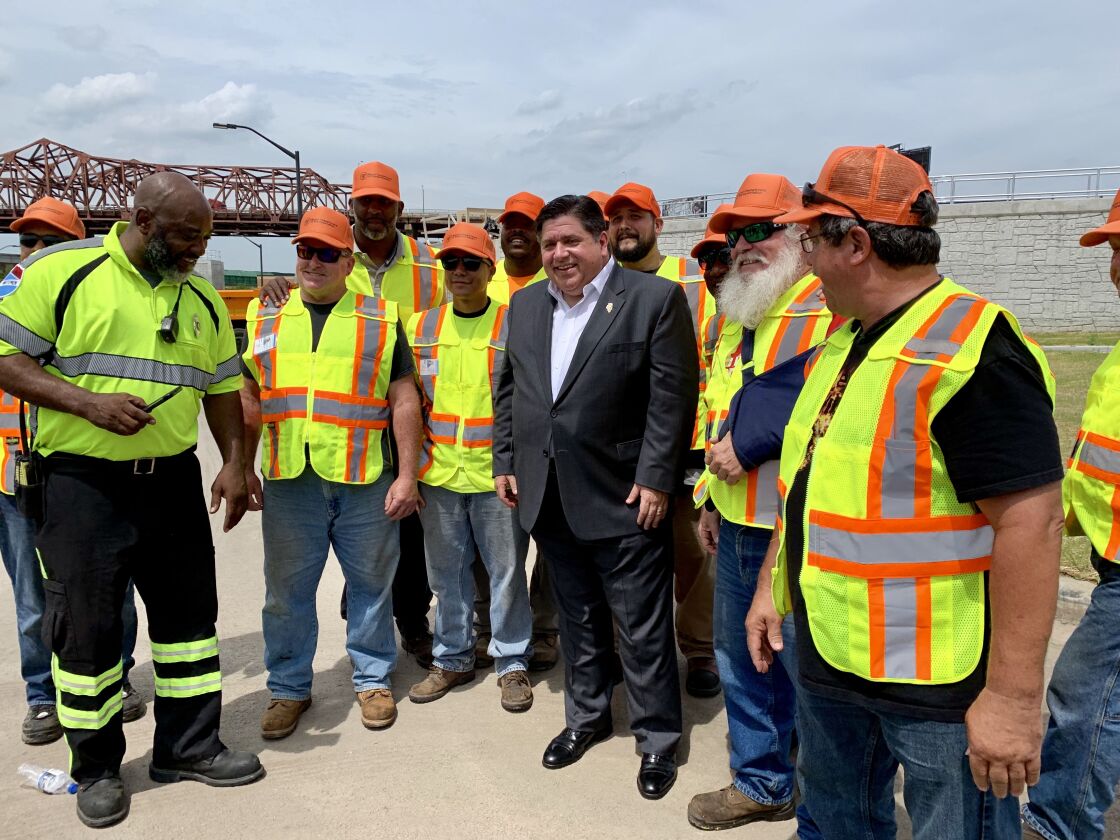 Gov. J.B. Pritzker poses with Illinois Department of Transportation workers near the Joliet Waste Water Treatment Facility.